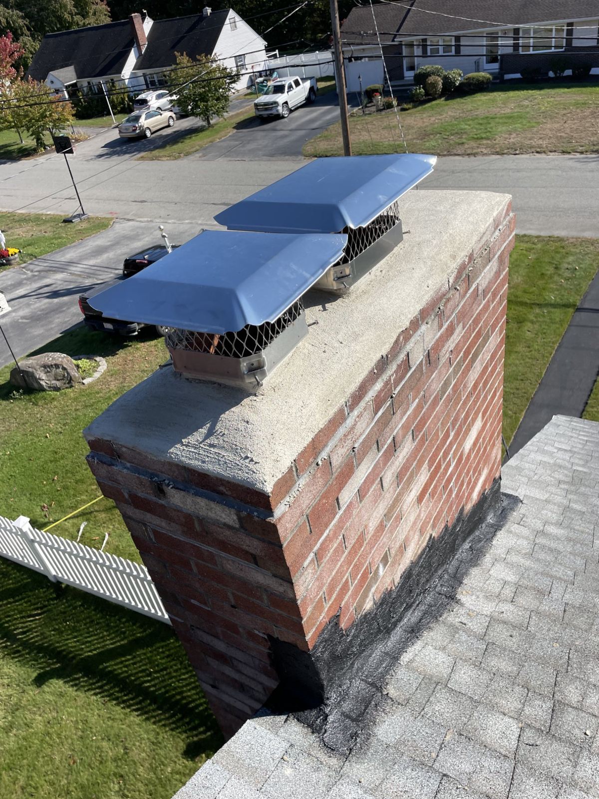 Double chimney cap installation with mesh spark arrestor in Boston