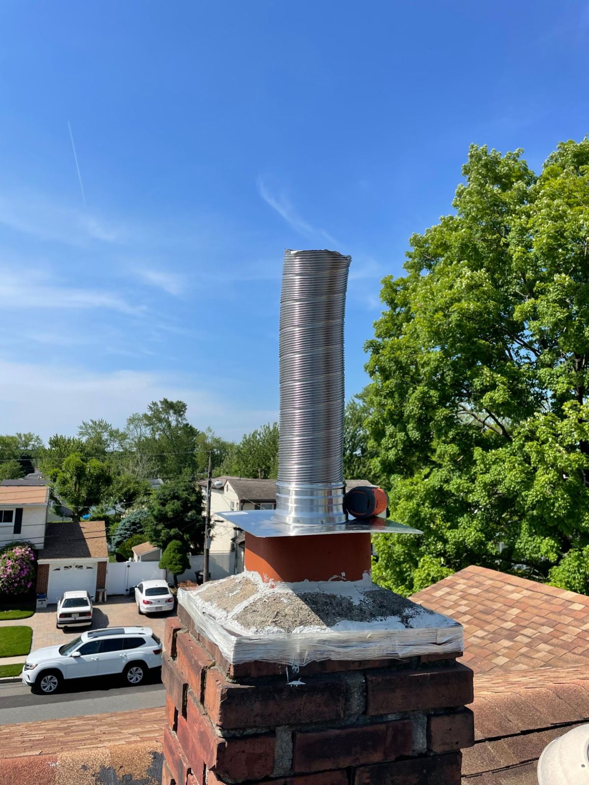 Chimney liner being installed on rooftop in Greater Boston