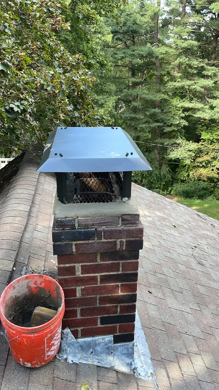 Finished full-coverage cap and brick chimney from the roof in Canton MA