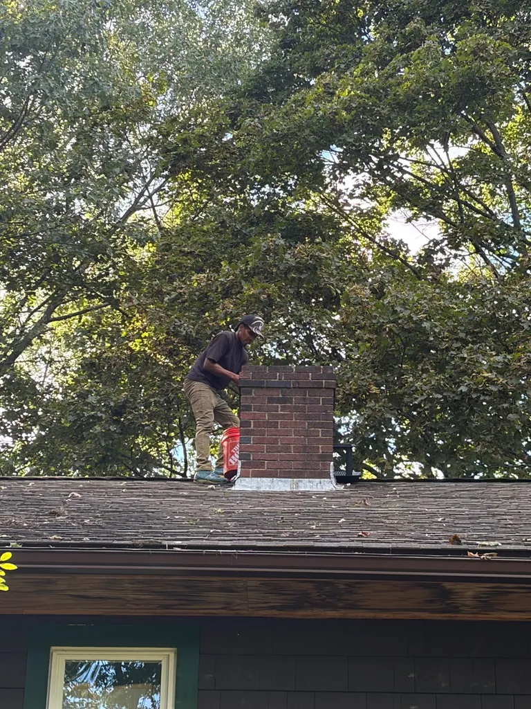Technician working on mortar at the top of a Canton MA chimney