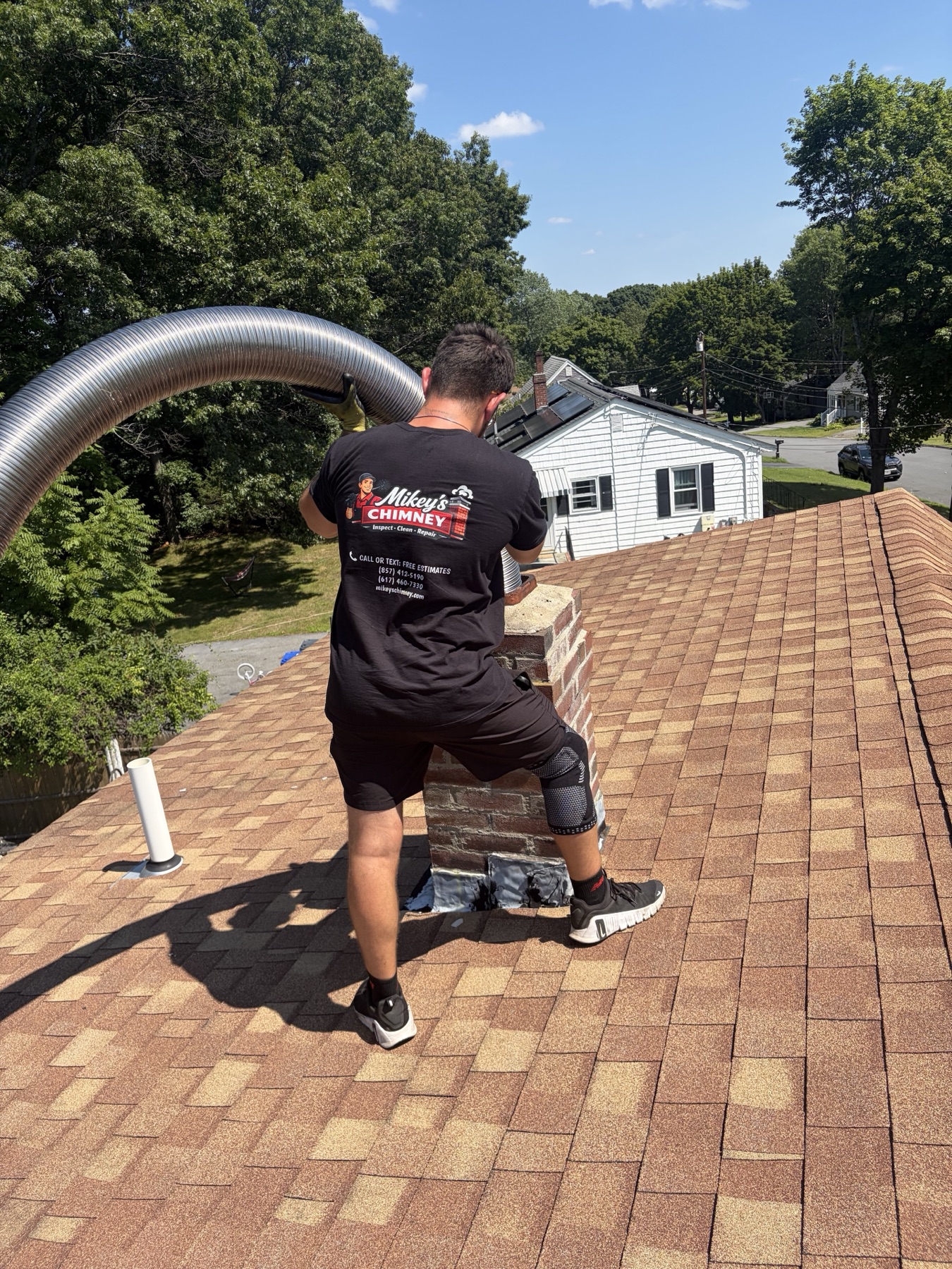 Technician installing chimney liner from roof in Methuen MA